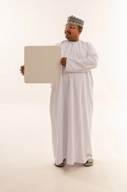 رجل عماني يحمل لوحة بيضاء في الاستوديو