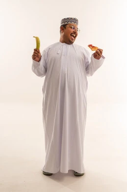 رجل عُماني مع بيتزا وموز في الاستوديو