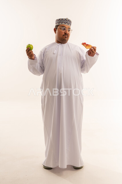 Omani Man Choosing Between Pizza and Apple Studio Shot