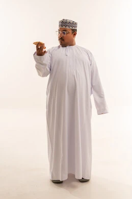 رجل عماني سمين يحمل طعاماً في الاستوديو