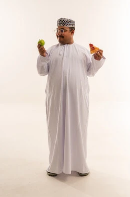 رجل عُماني يختار بين التفاح والبيتزا في استوديو