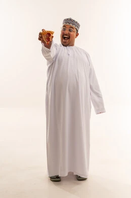 رجل عماني يحمل قطعة بيتزا بخلفية بيضاء
