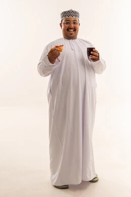 رجل عُماني مع بيتزا ومشروب غازي في الاستوديو