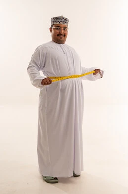 رجل عُماني يقيس خصره في استوديو تصوير