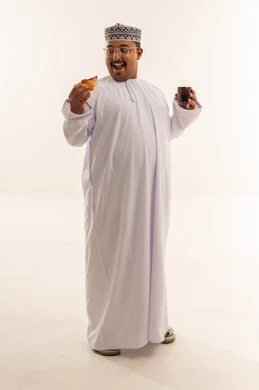 رجل عماني يأكل البيتزا مع مشروب غازي خلفية بيضاء
