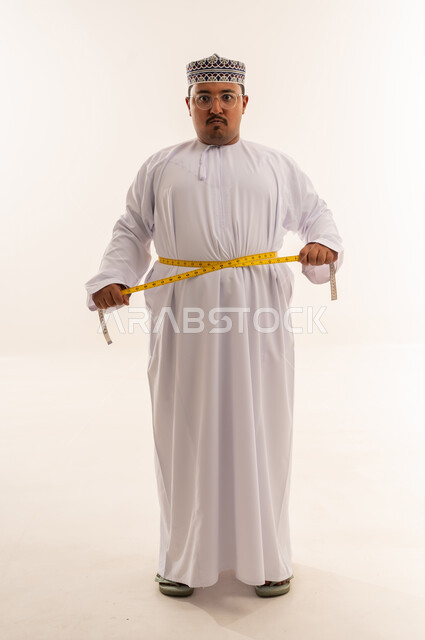 Omani Man Measuring Waist Against White Background