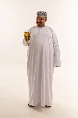 رجل عماني يمسك شريط قياس أمام خلفية بيضاء