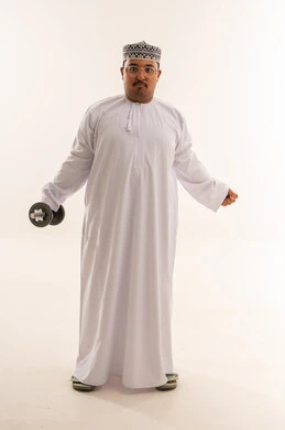 رجل عماني بدين يرفع الأثقال في الاستوديو