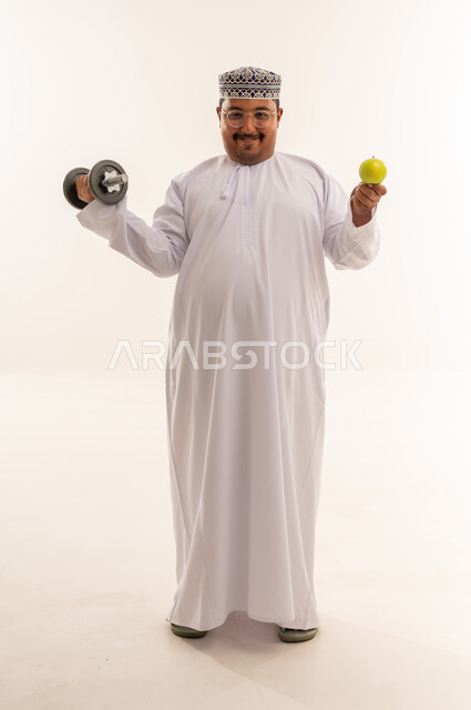 Omani Man with Dumbbell and Apple on White Background