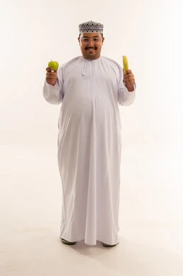 رجل عماني يحمل فاكهة في استوديو خلفية بيضاء