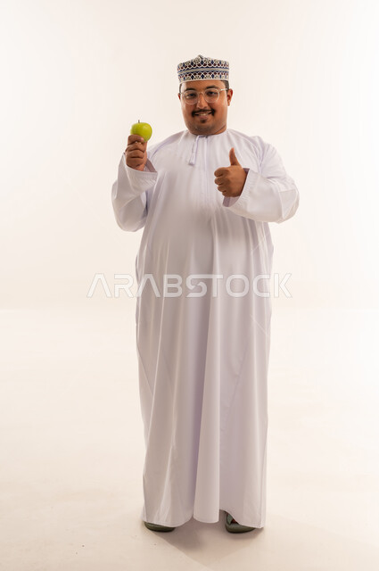 Omani Man Holding Green Apple With Thumbs Up
