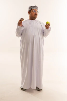 رجل عماني يختار بين التفاح والدونات خلفية بيضاء