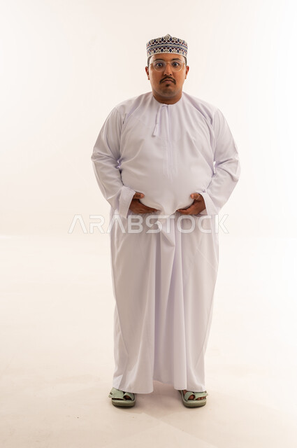 رجل عماني يعاني من السمنة يرتدي دشداشة بخلفية بيضاء