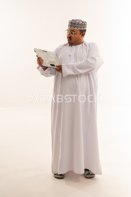 Overweight Omani Man with Weighing Scale in Studio