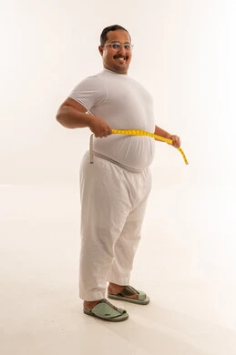 رجل سعودي بدين يقيس خصره في استوديو