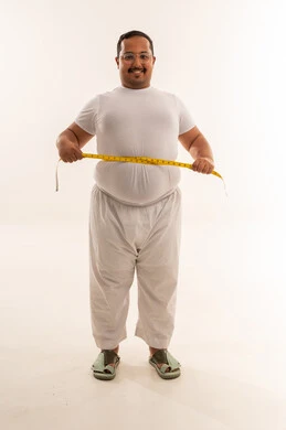 رجل سعودي بدين يقيس خصره في استوديو أبيض