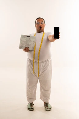 رجل عربي يعاني من السمنة يحمل ميزان وهاتف