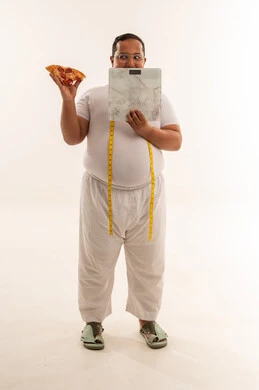 رجل عربي يعاني من السمنة مع بيتزا وميزان