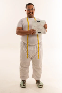 رجل سعودي يعاني من السمنة يحمل ميزان وزن