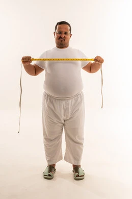 رجل سعودي يعاني من السمنة مع شريط قياس
