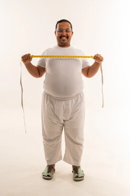 رجل سعودي بدين مع شريط قياس في الاستوديو