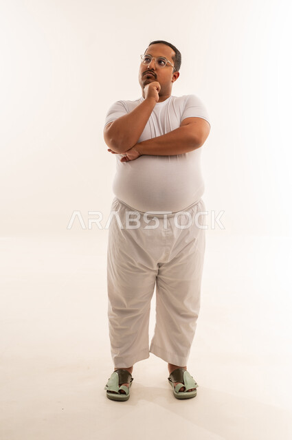 رجل عربي بوزن زائد يفكر في استوديو أبيض