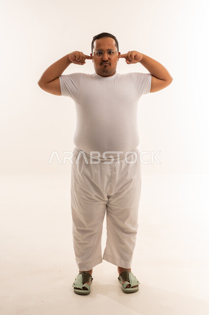 رجل سعودي يغلق أذنيه بخلفية بيضاء