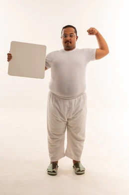 رجل سعودي بدين يستعرض عضلاته ويحمل لوحة فارغة