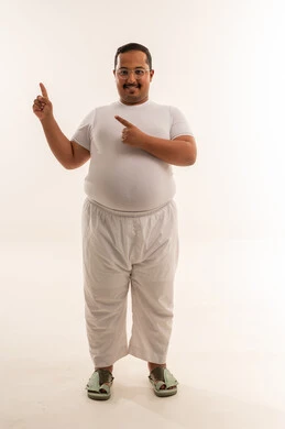 رجل سعودي بوزن زائد يشير للأعلى بخلفية بيضاء