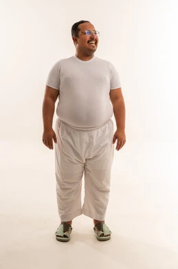 رجل سعودي بدين مبتسم في استوديو بخلفية بيضاء