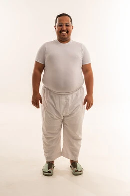 رجل سعودي بدين يقف في استوديو أبيض