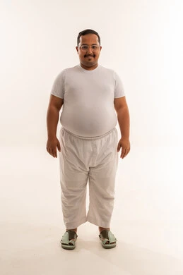 رجل سعودي بدين يقف في استوديو أبيض