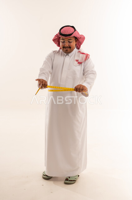رجل سعودي يقيس محيط خصره في الاستوديو