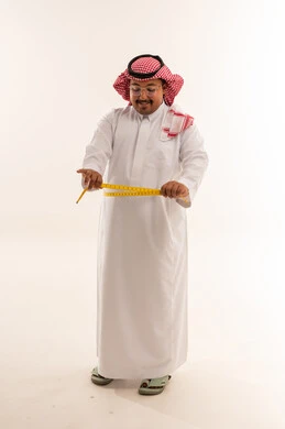 رجل سعودي يقيس محيط خصره في الاستوديو