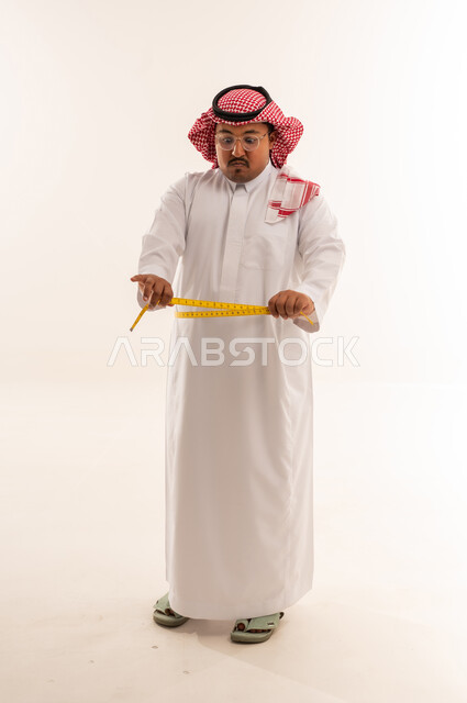 رجل سعودي يعاني من السمنة يقيس خصره