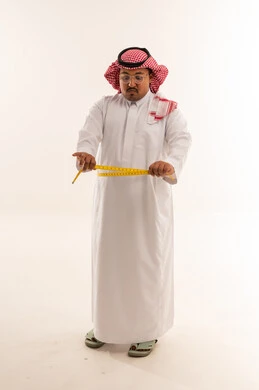 رجل سعودي يعاني من السمنة يقيس خصره