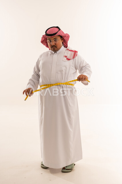 رجل سعودي بدين يقيس خصره في الاستوديو