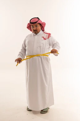 رجل سعودي بدين يقيس خصره في الاستوديو