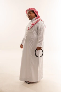 رجل سعودي بدين يقف على ميزان في استوديو