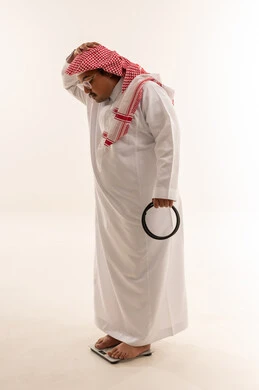 رجل سعودي سمين على ميزان قياس الوزن في الاستوديو