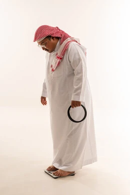رجل سعودي يعاني من السمنة على الميزان