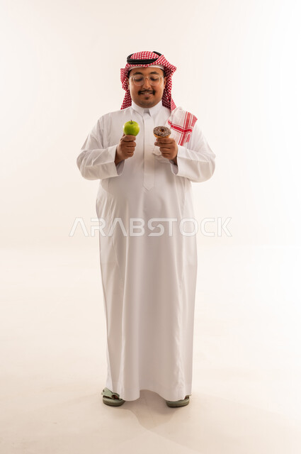 رجل سعودي يختار بين التفاح والدونات في الاستوديو