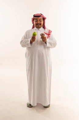 رجل سعودي يختار بين التفاح والدونات في الاستوديو