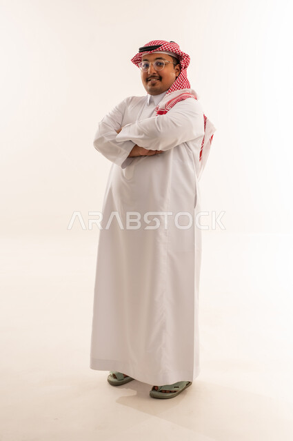 رجل سعودي ببدنية ممتلئة بالثوب التقليدي في الاستوديو