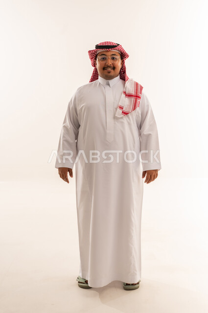 رجل سعودي مبتسم بالثوب التقليدي في الاستوديو