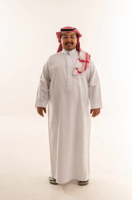 رجل سعودي مبتسم بالثوب التقليدي في الاستوديو