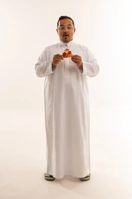 رجل سعودي بوزن زائد مندهش يحمل قطعة بيتزا