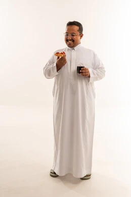 رجل سعودي بدين يأكل البيتزا في الاستوديو