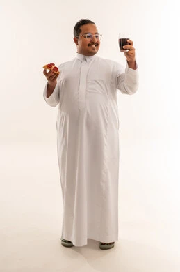 رجل سعودي بدين مع بيتزا ومشروب غازي في الاستوديو