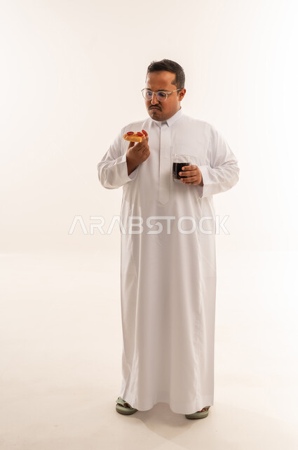 رجل سعودي بالثوب يحمل بيتزا ومشروب غازي